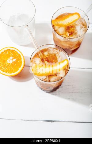 Refreshing soft drinks, including a cold drink coffee cocktail and citrus espresso tonic, decorated with orange zest and glass straws Stock Photo