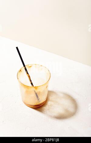 Coffee glass empty and dirty after drinking on white beige background with shadow.Trendy minimalist style Stock Photo