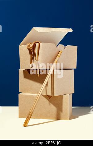 Creative composition of three paper eco boxes package and chopsticks on blue background.Concept of delivery restaurant and asian take away food Stock Photo