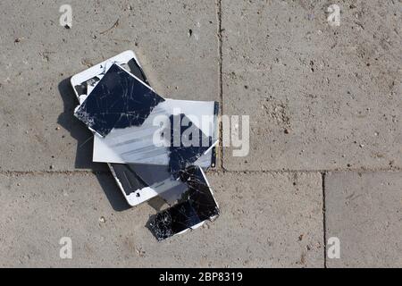 Broken screen mobile phone lies on ground. Stock Photo