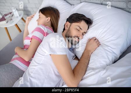 Young pregnant couple sleeping in bed 