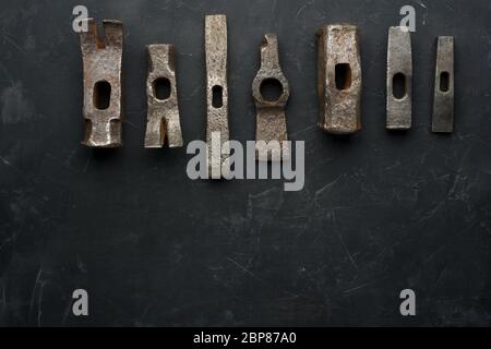 Old rusty hammers on dark background with place for text. Minimal black. Stock Photo