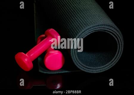 Exercise mat with weights. Professional sport equipment isolated on black studio background. Concept of sport, leadership, competition, healthy lifestyle in motion and action, training, close up Stock Photo