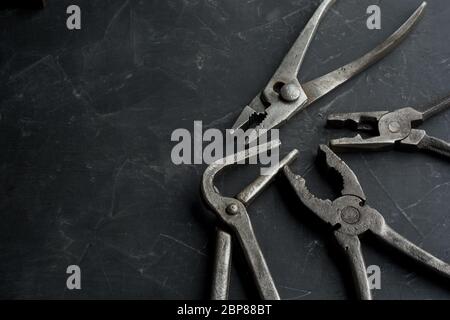old vintage pliers on a dark concrete background, close up, copy space Stock Photo