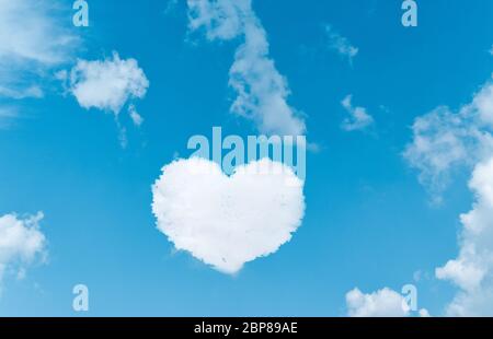 Heart shaped clouds on blue sky background. Stock Photo