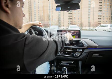 unrecognizable man use the surround camera on the touchscreen display. modern technologies, driving and parking safety. Close up, background in blur Stock Photo