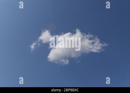 Single white cloud on blue sky background. Stock Photo