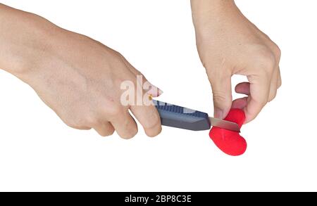 hand holding a knife cutting red heart isolated on white background with clipping path. break heart concepts. Stock Photo