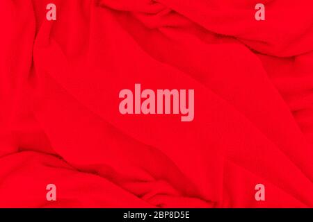 Red fabric texture background. Abstract cloth backdrop with soft waves. Stock Photo