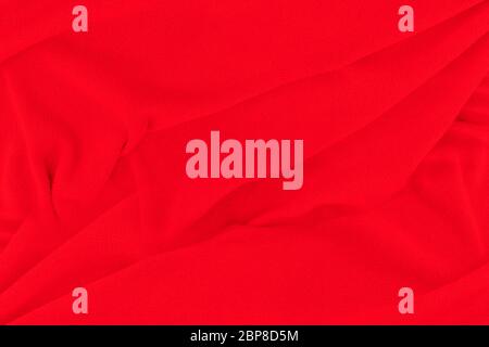 Red fabric texture background. Abstract cloth backdrop with soft waves. Stock Photo