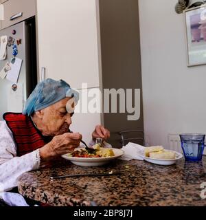 Elderly Woman Eating Alone, Self Isolating During The UK Coronavirus Lockdown, Eating A Meal Stock Photo