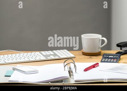 Open folder with keyboard and phone lying on wooden desk Stock Photo