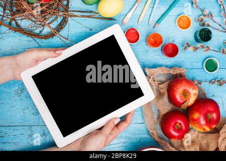 Easter in the office workplace on blue wooden table. The female hand with laptop Stock Photo