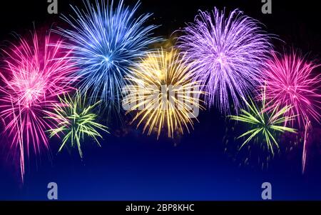 Gorgeous multi-colored fireworks as an arch shaped border on dark blue background, ideal for New Year or other celebration events Stock Photo