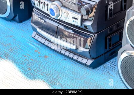 Poltavskaya, Russia - March 24, 2016: Cassette tape recorder with radio on a blue wooden table. Vintage technique from the 90s. Stock Photo