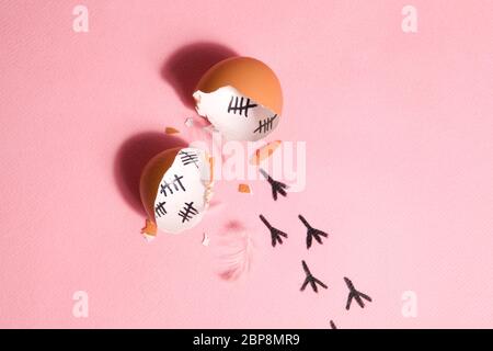 The counting of the days on a broken egg with footprint on a pink and blue background Stock Photo