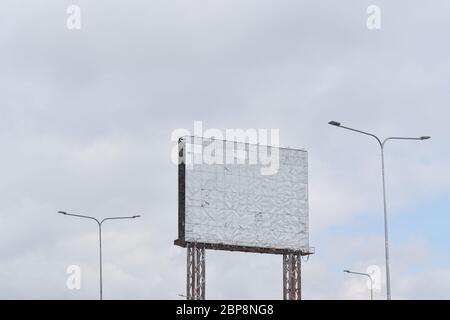 Old empty billboard stainless against blue sky background for advertisement or design. Stock Photo