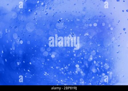 Lot of small bubbles on an blue background, macro shot of liquid soap, macro shot of glass with beer, macro shot of cocktail with fruit juice Stock Photo