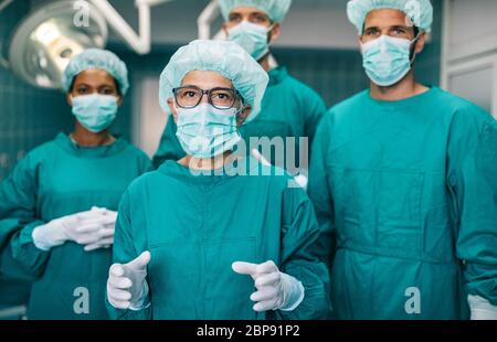 Team of surgeons in the operating room preparing for surgery Stock Photo