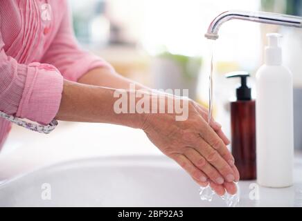 Unrecognizable woman washing hands at home, corona virus concept. Stock Photo