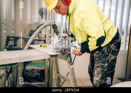 Master cuts the tile using an angle grinder with special diamond disc. Stock Photo