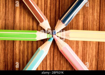 Crayons pointing to center. Symbolical image central power meeting at a point. Close-up of a selection of Multi Colored pencils, close together arrang Stock Photo