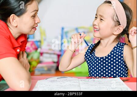 Asian children and Mother teach doing school home work during the COVID-19 quarantine. Coronavirus isolation. online studying from home Stock Photo