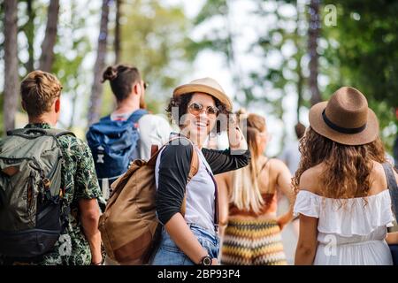 Rear view of group of young friends at summer festival, walking. Stock Photo