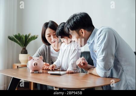 Mom and Dad and daughter at home, the number of coins Stock Photo