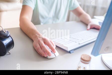 the developer works at the computer, uses mouse Stock Photo