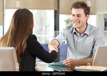 Happy businesspeople handshaking after negotiation at office Stock Photo
