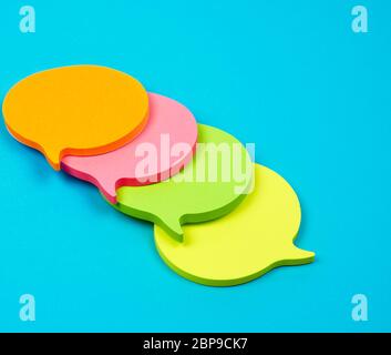 stack of multicolored empty paper stickers in the form of clouds on a blue background Stock Photo