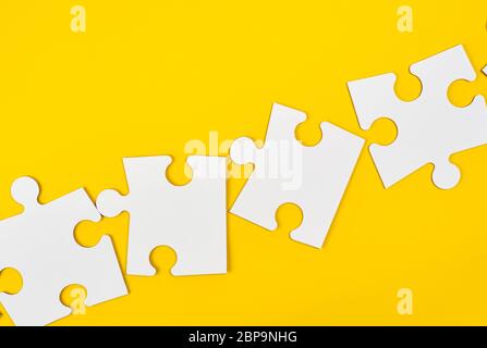 blank white big puzzles on yellow background, flat lay Stock Photo