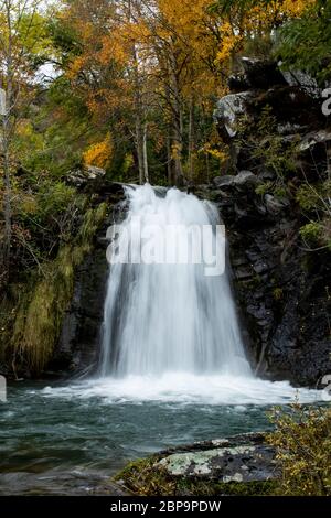 Vertical shot of the lighthouse river waterfall as it passes through the town of Redipuertas in Leon Stock Photo