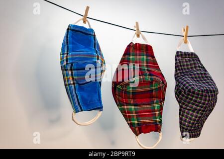 Different colors of washable face masks hanging to dry after washing. Fashionable face masks reusable and washable. Stock Photo