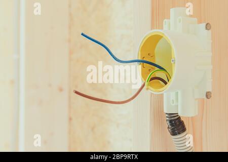 Close Up Of Wall Outlet Box With Set Of Wires Exposed In New Home Construction. Stock Photo