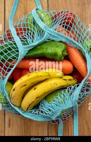 Cotton string eco bag with fruits and vegetables on wooden background Stock Photo