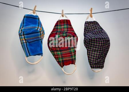 Different colors of washable face masks hanging to dry after washing. Fashionable face masks reusable and washable. Stock Photo