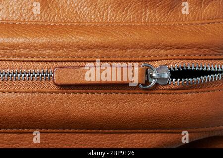 Open zip lock on brown leather background close up view Stock Photo