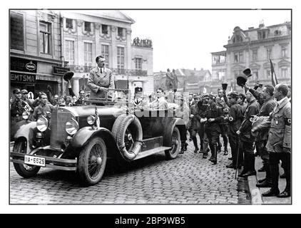 Adolf Hitler 1920’s Rally NSDAP Nazi Party pre election rally in Weimar Germany 3–4 July 1926, Hitler wearing civilian clothes standing in his open top Mercedes limousine motorcar with Rudolf Hess seated in the rear of the car. Various swastika armband wearing supporters cheering his arrival Stock Photo