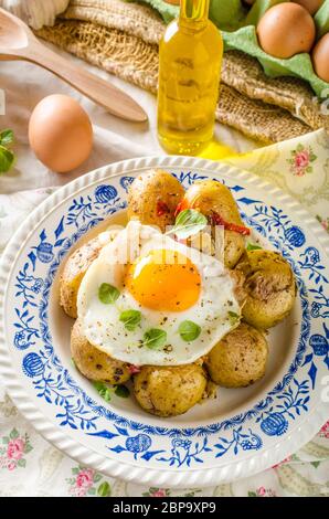 Baked potato with chili and fried egg, fresh young tomatoes and spicy chilli with herbs, great combination of flavours and spicy. Stock Photo