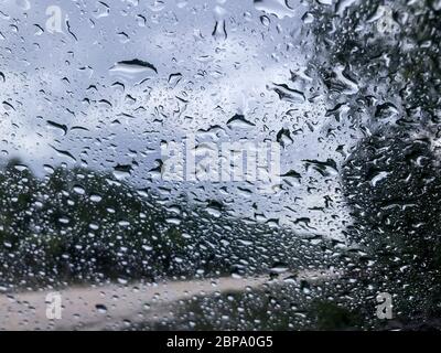 Raindrops collect on automobile windshield during rainy day in the Big Cypress Preserve, Everglades, Florida Stock Photo