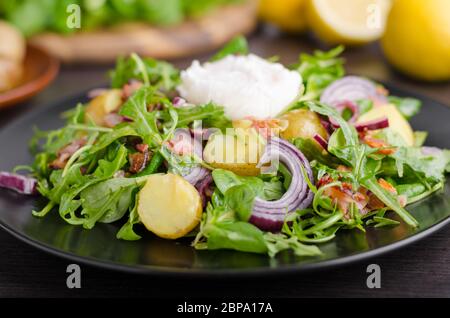 Potato lettuce salad with poached egg and onion Stock Photo