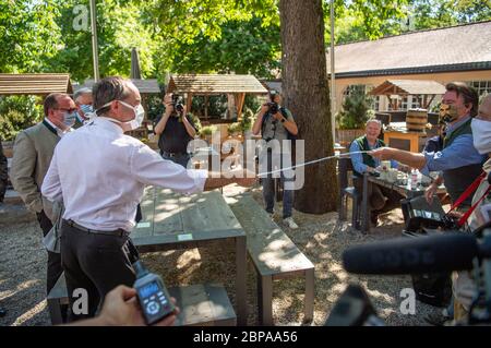 Munich, Germany. 18th May, 2020. Hubert Aiwanger (Free Voter, 3rd from left), Minister of Economic Affairs of Bavaria, is presented with a measuring tape by beer garden visitor Harald Kaiser during his visit. Aiwanger visited a beer garden in Munich at the start of outdoor gastronomy and looked at the hygiene concept. Credit: Lino Mirgeler/dpa/Alamy Live News Stock Photo