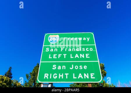 Interstate 280 highway road sign providing information to drivers the directions to San Francisco and San Jose in sunny Silicon Valley. Green trees an Stock Photo