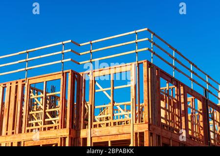 New residential wood framed building construction under blue sky. Stock Photo