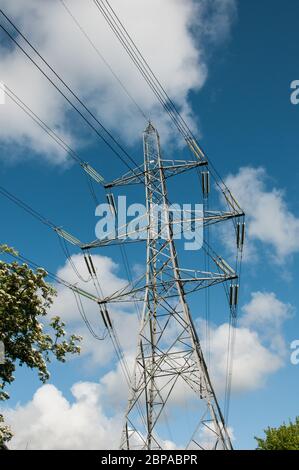 Around the UK - Electricity Pylons against a blue sky with white fluffy clouds Stock Photo