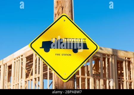 Fire station road sign. Blurred background wood framing building construction of new building. Stock Photo