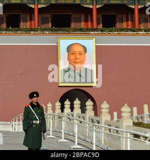 Beijing / China - January 25, 2014: Chinese soldier stands guard in front of the main gate of Forbidden city with portrait of Mao Zedong, Tiananmen Sq Stock Photo