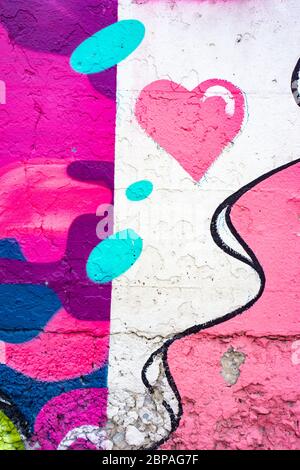 Abstract colorful graffiti background wall featuring urban art work with colors of, white, pink, purple and blue. Stock Photo